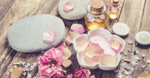 Spa essentials with marble stones, rose petals, salt, candle and oil