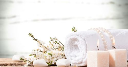 Spa setup with towel, candle and flower